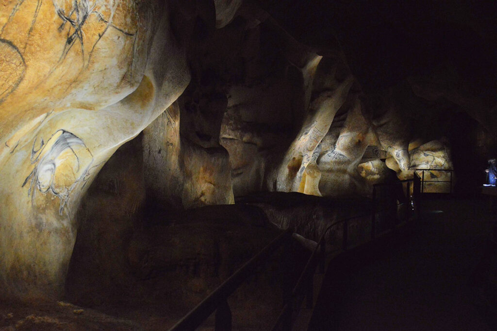 Vue en enfilade des éclairages et des fresques © Ponctuelle - Caverne du Pont d'Arc