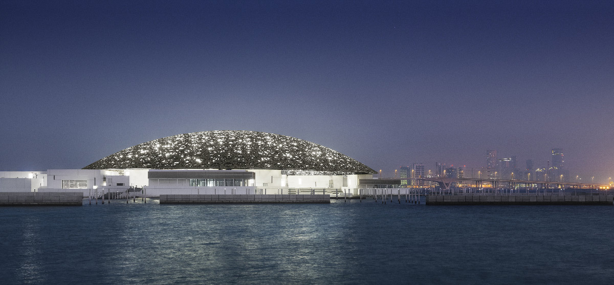 Mise en lumière extérieure du dôme du musée du Louvre Abu Dhabi avec la ville à l'horizon la nuit - Architectes : Jean Nouvel et Hala Warde