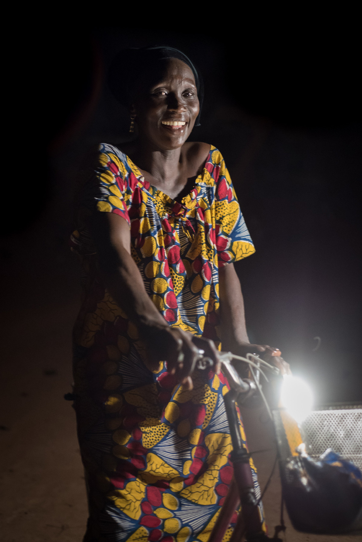 Lampe solaire Kalo 1500 et femme avec un vélo - Fabricant : Lagazel © Nicolas Remene