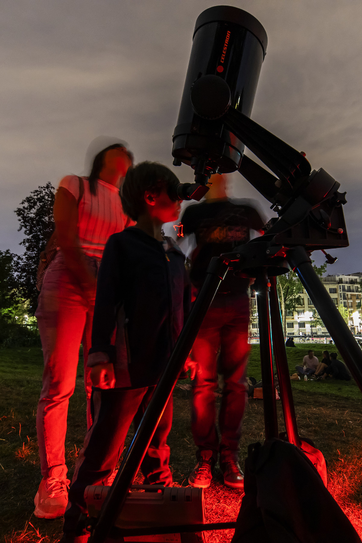 Observateurs du ciel et télescope sur un trépied et lumière rouge comme si on était sur la planète Mars